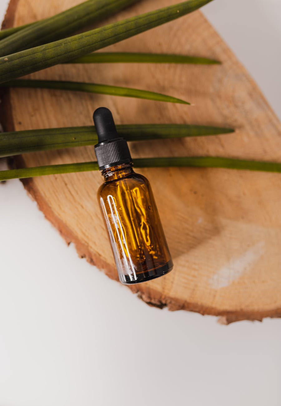 small essential oil bottle on decorative tree trunk